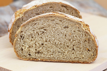 Half a rustic bread on wooden board
