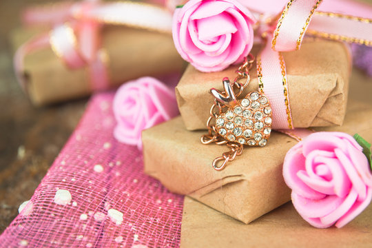 Gift box decor. Wrapped in parchment paper, delicate fresh pink flowers with golden heart