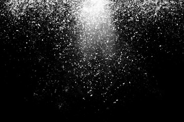 Freeze motion of white powder coming down, isolated on black, dark background. Abstract design of falling dust cloud. Particles cloud screen saver, wallpaper with copy space. Rain, snow fall concept