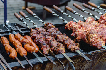 cooking meat and sausages on skewers