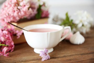 Obraz na płótnie Canvas Cup of tea and flowers on wooden table