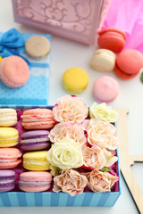Tasty macaroons in box on white background