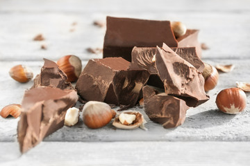 Chocolate pieces with nuts on wooden background