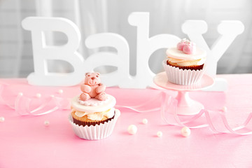 Letters of word baby and cupcakes on the table