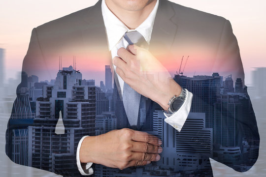 Businessman held necktie dress to look good and city, urban and sunset at evening as preparation and leadership concept.