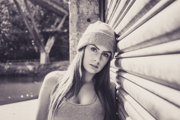 Portrait of beautiful young female model, leaning against garage