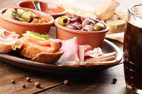 Tapas of salmon, mussels, jamon and olives with beer