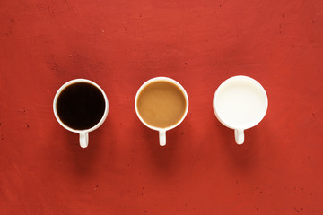 Three cups with coffee and milk