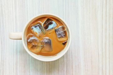 Iced coffee in mug on wooden