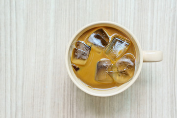 Iced coffee in mug on wooden