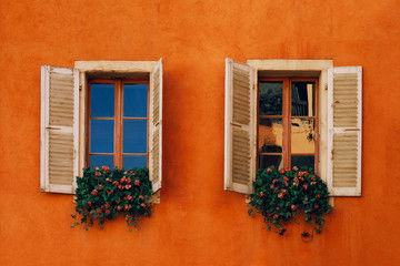 Fototapeta na wymiar Two window in the wall with flowers - Annecy, France