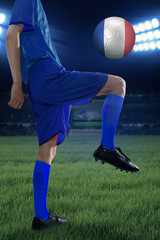 Fototapeta na wymiar Football player exercises with a ball