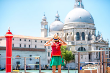 Young female traveler standing on the pier with great view on Santa Maria basilica in Venice