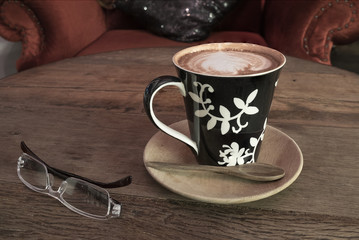 hot coffee with tissue paper coffee on wooden table coffee and sunglasses coffee near red sofa