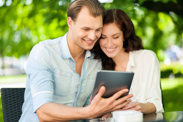 Couple using a tablet at the park