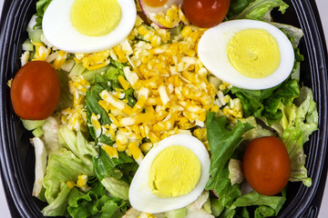 fresh tossed garden salad of lettuce egg cherry tomato and grated cheese