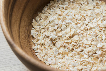 Oatmeal breakfast cereal over wooden bowl