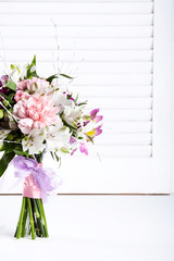 Pastel bouquet from pink and purple gillyflowers on white shutte