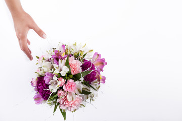 Hand receiving a pastel bouquet from pink and purple gillyflower