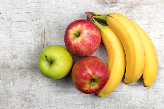 Äpfel und Bananen auf Holz Hintergrund