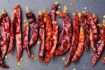 Dried red chili peppers on slate background Top view Copy space