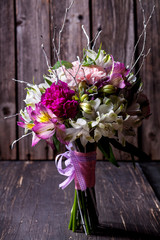 Pink bouquet from gillyflowers and alstroemeria on old wooden ba
