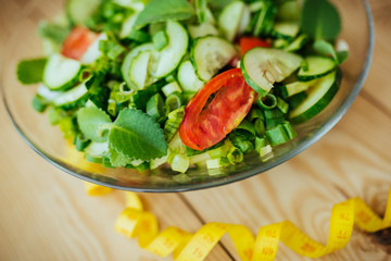 Diet plan, menu or program, tape measure and diet food of fresh vegetable salad, lemon on wood background, weight loss and detox concept, top view