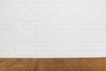 Wooden table with blurred white birck wall on the background, can be used for product montage