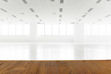 Wooden table with blurred background of white empty room, can be used for product montage