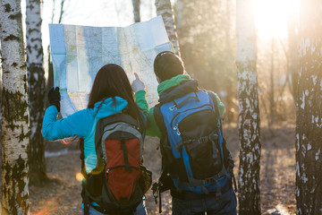 Young couple hikers looking at map.