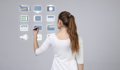 Woman pressing multimedia and entertainment icons on a virtual background
