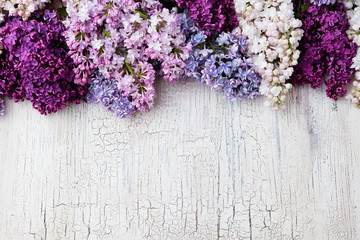 Bunch of lilac flowers on a crackling wooden background Top view copy space