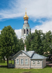 Fototapeta na wymiar Bell tower in Vologda and wooden house