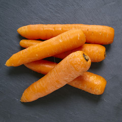 Food and root vegetables - A pile of carrots on a slate chopping board background