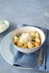 Colorful gnocchi trio (potato, spinach and tomato) with cream sauce and grated parmesan. Selective focus.
