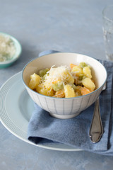 Colorful gnocchi trio (potato, spinach and tomato) with cream sauce and grated parmesan. Selective focus.