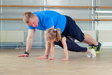 Group of children doing kids gymnastics in gym with nursery teacher
