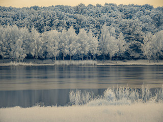 Infrared view at lake`s surface under the stormy clouds