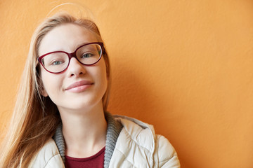 Blonde junge Frau vor Wand