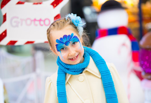 Portrait of little girl with Christmas face painting 