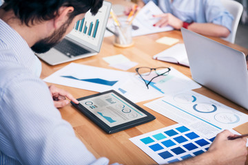 Pleasant busy man sitting at the table