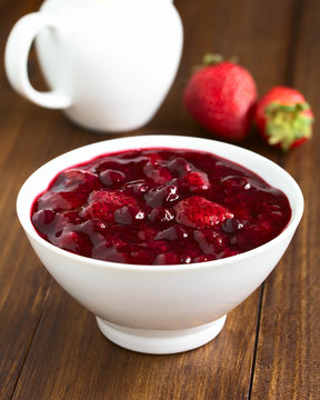 German Rote Gruetze (red groats) red berry pudding made of strawberry, blueberry, raspberry, redcurrants, photographed with natural light (Selective Focus, Focus one third into the dessert)