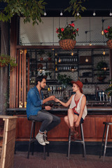 Obraz premium Couple sharing cigarette at coffee shop