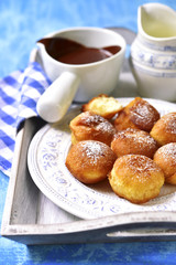 Vanilla doughnuts with chocolate sauce.