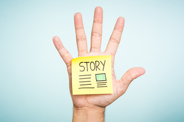 Story newspaper note on hand and blue background. Social media concept.