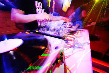 DJ behind the decks in a nightclub.