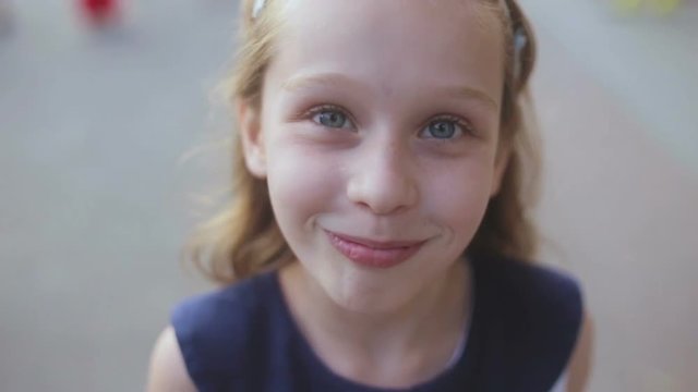 Close up of a young girl smiling as she looks into the camera