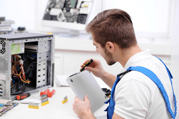 Fototapeta na wymiar Young repairer working with screwdriver in service center