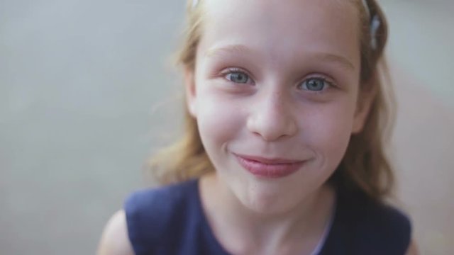 Close up of a young girl smiling as she looks into the camera