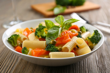 Plate of pasta with salmon and broccoli on table closeup